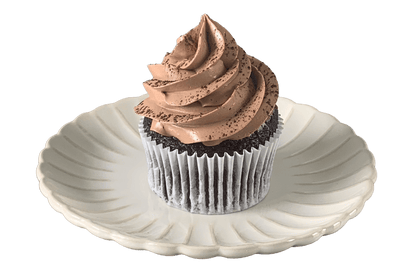 Placed on a white vintage style plate is a chocolate sponge cupcake topped with Belgian chocolate Swiss meringue buttercream. 