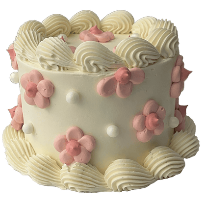  A small mini round shaped Swiss meringue buttercream cake with a white base colour and white piped shells.  Pretty pink daisies have been piped on the top and sides of the cake and some sugar pearls added to complete the decoration.