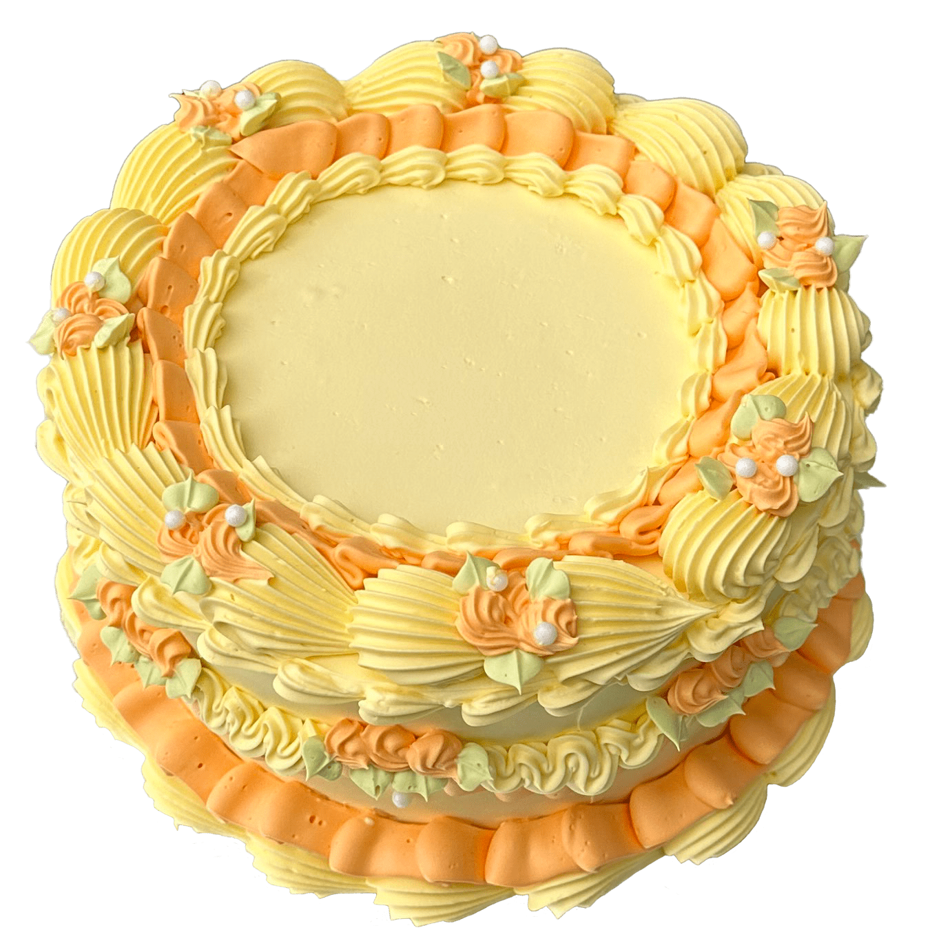 A classic round shaped vintage style cake coated with a yellow base colour swiss meringue buttercream and a simple orange piped ruffle around the outer edge and on top.  There are also a mixture of yellow large and small piped shells and small orange rose swirls with pastel green leaves and pearl decorations.  The top center of the cake is coated flat and smooth with  buttercream allowing for a message to be written.