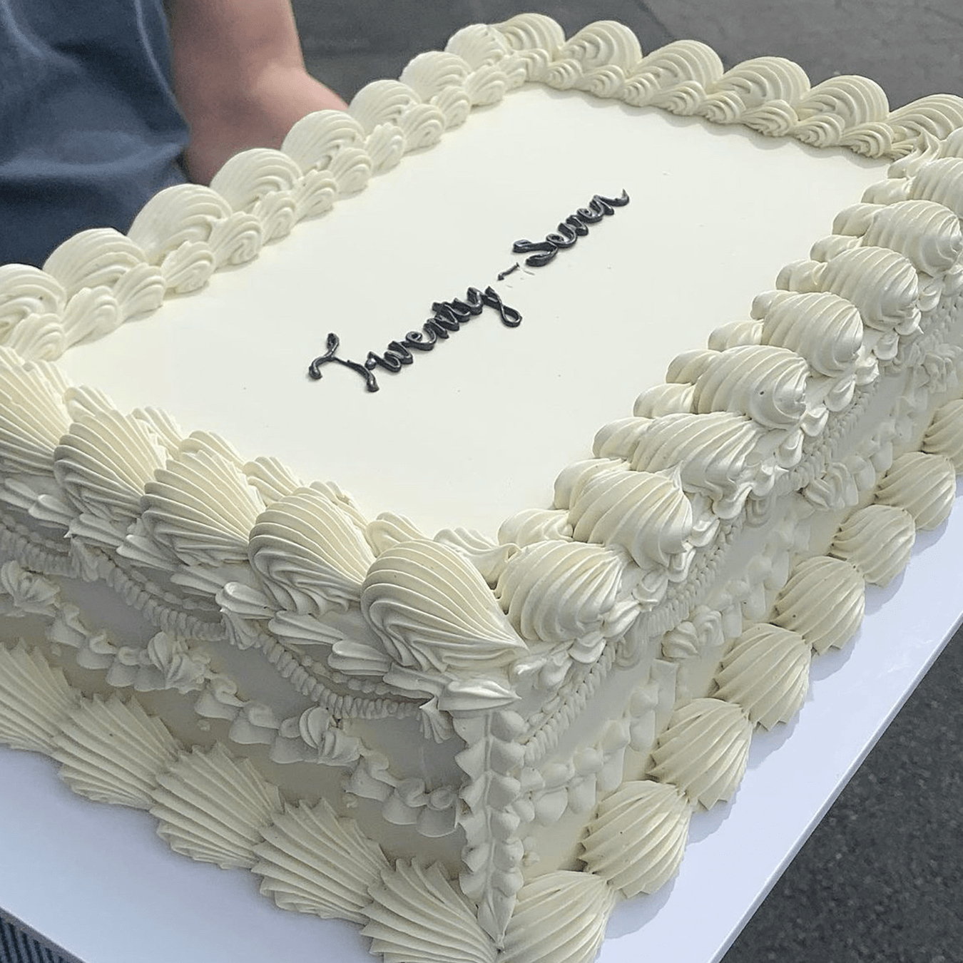 A very large vintage style sheet all white slab-cake covered in a white Swiss meringue buttercream with intricate ornate piping.  Big enough to feed a crowd or party for any birthday or wedding celebration.